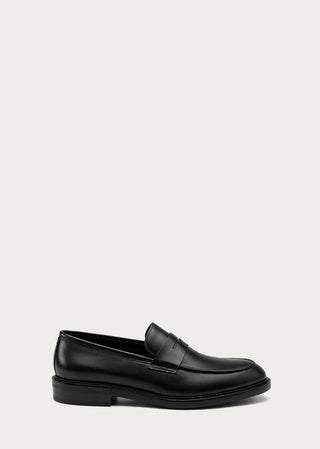Side view of black leather loafer with minimal silhouette.