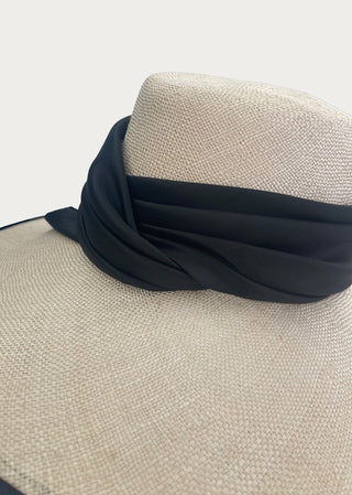 Close-up detail of the handcrafted Lucia Hat featuring woven natural fibers and a soft black textile band