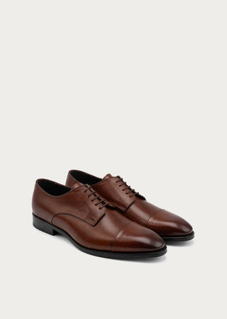 Pair of brown Italian leather lace-up shoes with classic cap-toe design on a neutral background.