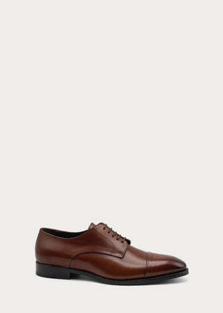 Side view of brown leather lace-up shoe with elegant cap-toe silhouette on a neutral background.