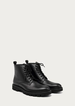 Pair of black leather lace-up boots with rugged sole on a neutral background.