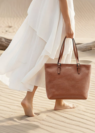 Brown leather tote bag by Copardo carried in a desert setting, minimalist luxury style