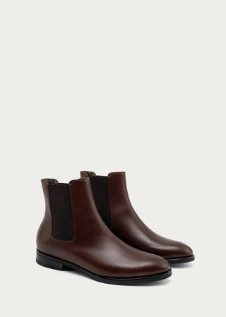 Pair of brown Italian leather Chelsea boots with clean minimalist silhouette on a neutral background.